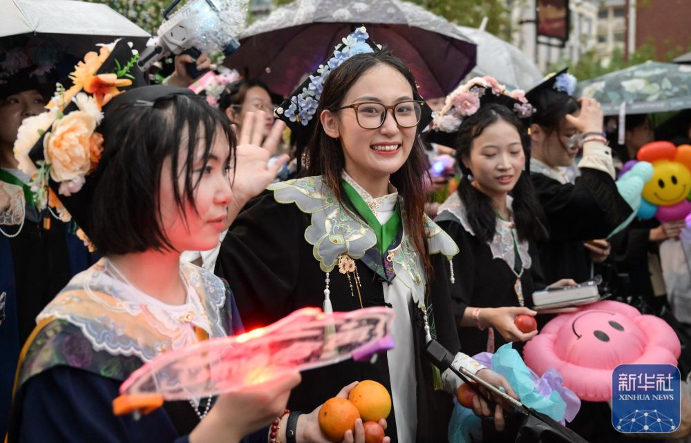 6月21日，华中农业大学学生在校园里冒雨巡游。